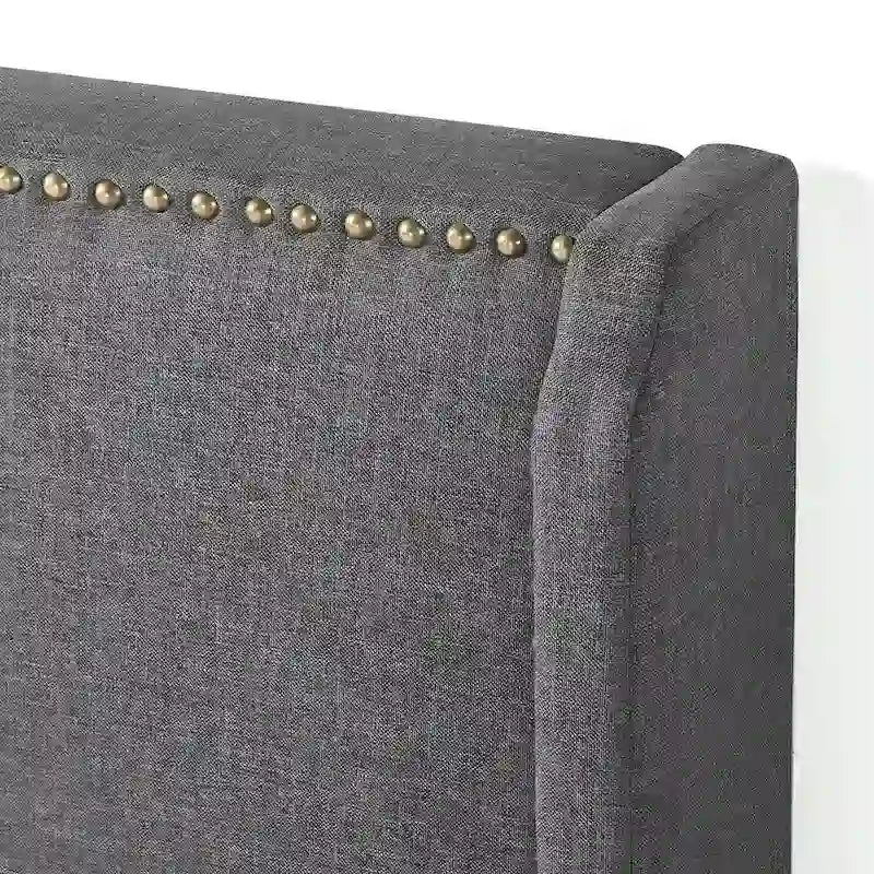 Lit plateforme gris foncé avec revêtement rembourré, dossier haut à ailes, clous décoratifs et lattes en bois